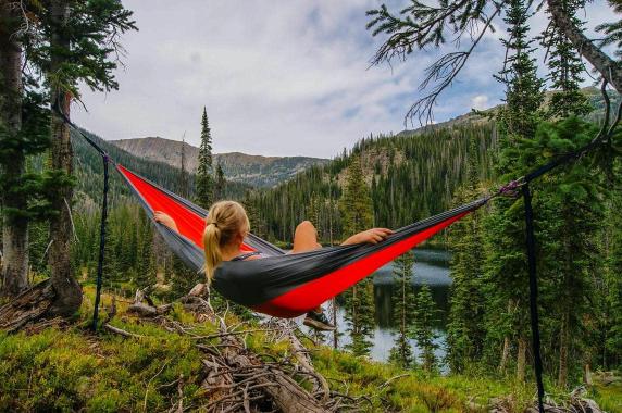 Person sitting in a hammock surrounded by nature