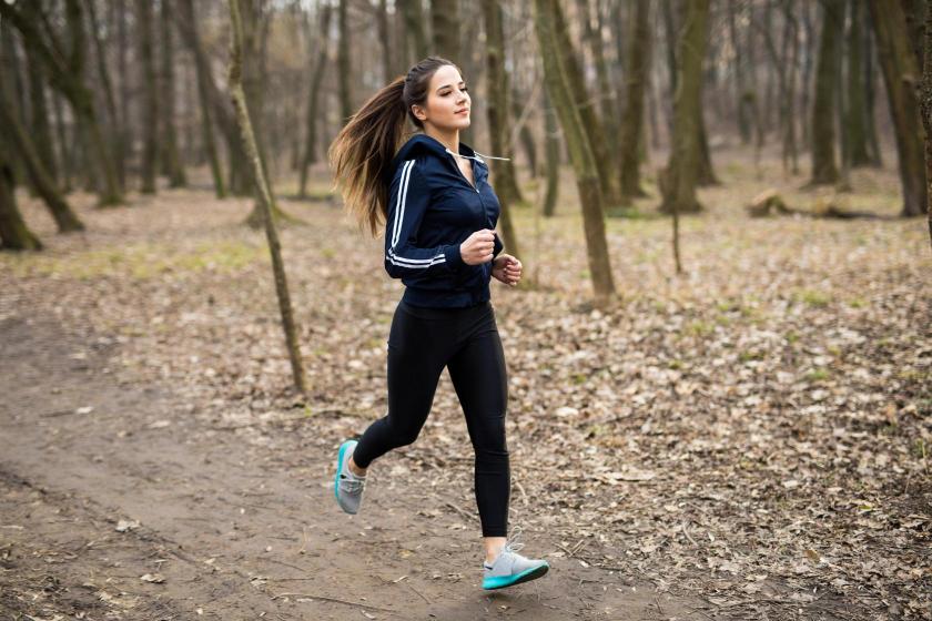 Person running through a forest in fall