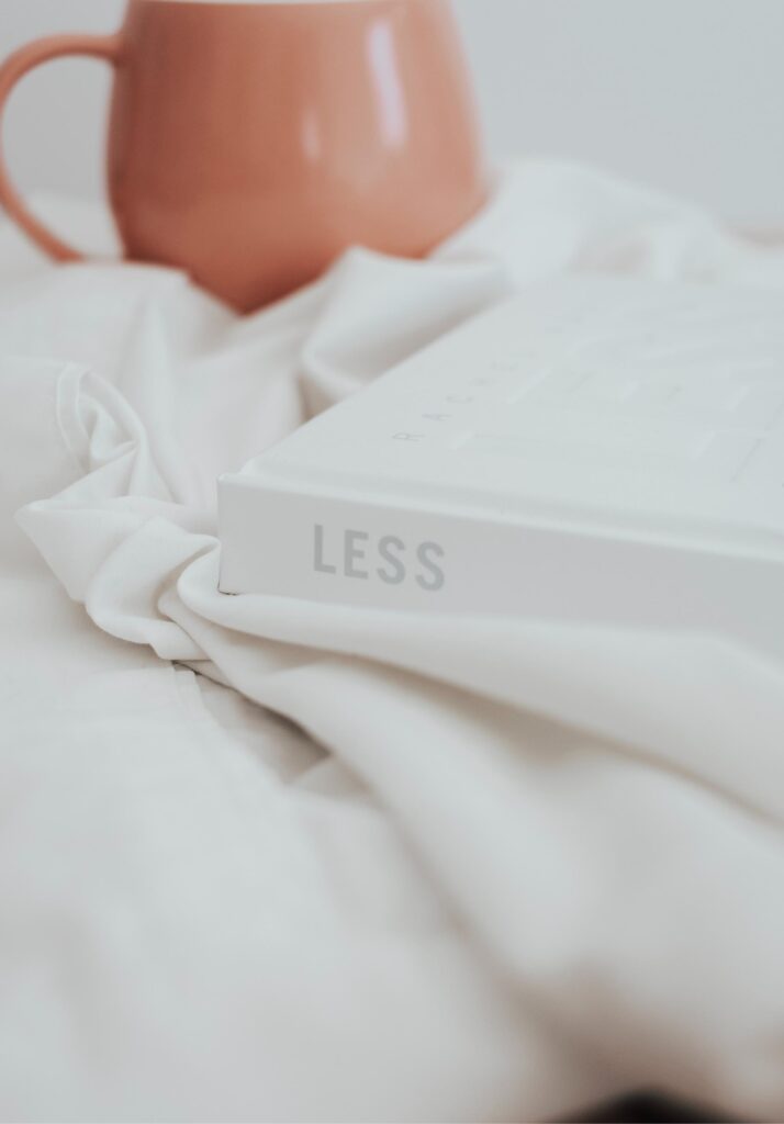White book with the word "Less" on the spine against a minimal background