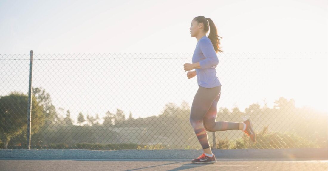 Person running outside with sun shining brightly in the background