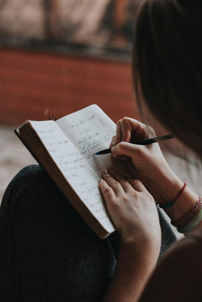 Person writing their thoughts in a journal